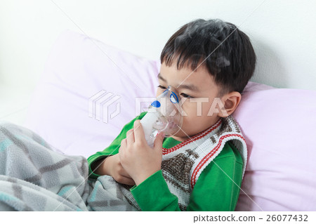Illmess asian child holds a mask vapor inhaler. Illmess asian child holds a mask vapor inhaler. 26077432