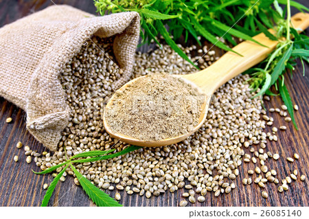 Flour hemp in spoon with bag and grains on board 26085140