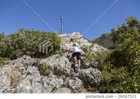 teenage boy is climbing a mountain top 26087321
