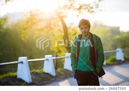 Young man walking around city listening to music 26087593