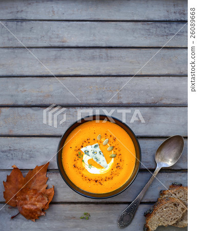 Pumpkin soup a wooden table. 26089668