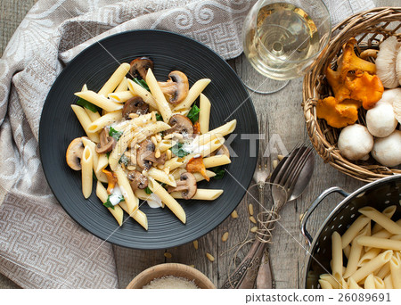 Pasta with mushrooms on rustic tabletop. 26089691
