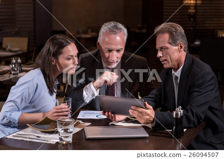 Involved business partners looking at the tablet 26094507