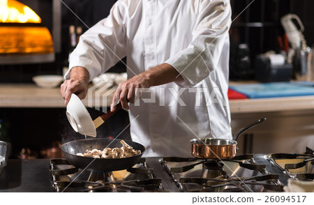 Hardworking chef frying mushrooms in the kitchen 26094517