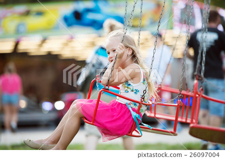 Cute little girl at fun fair, chain swing ride Cute little girl at fun fair, chain swing ride 26097004