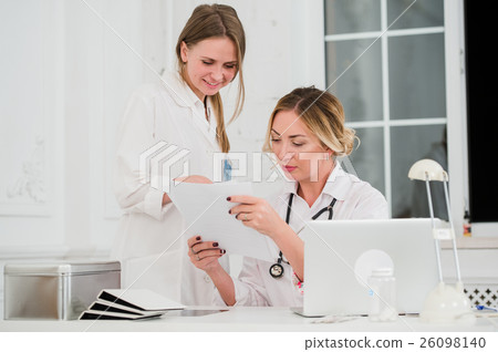 Doctor and nurse looking at docments in medical Doctor and nurse looking at docments in medical 26098140