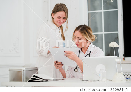 Doctor and nurse looking at docments in medical Doctor and nurse looking at docments in medical 26098141