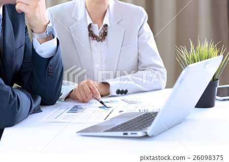 colleagues working and analyzing financial figures 26098375