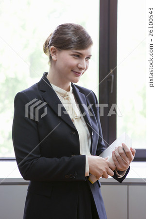 Businesswoman standing with a book Businesswoman standing with a book 26100543