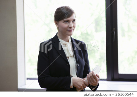 Businesswoman standing with a book Businesswoman standing with a book 26100544