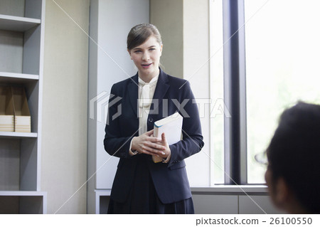 Businesswoman standing with a book Businesswoman standing with a book 26100550
