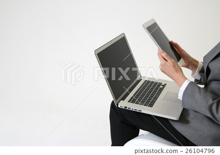 A woman using a tablet and a laptop 26104796