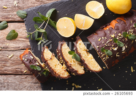 Sliced lemon cake with chocolate glaze and zest 26105693