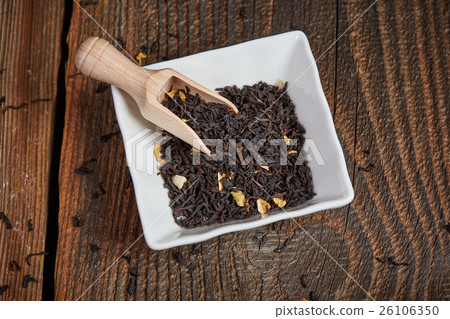 Tea leaves in a bowl on a wooden table 26106350
