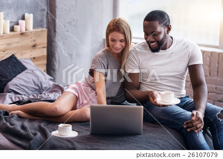 Sweet couple lying in bedroom with laptop Sweet couple lying in bedroom with laptop 26107079