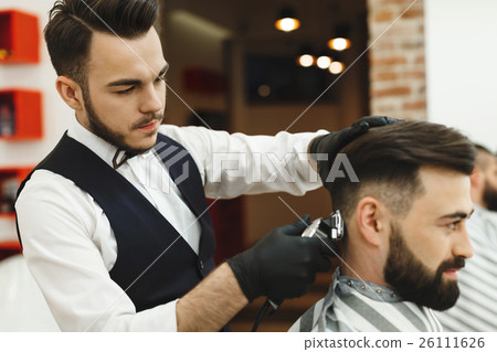 Man with dark hair doing a haircut Man with dark hair doing a haircut 26111626