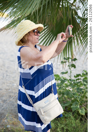Adult woman photographing by telephone 26112066