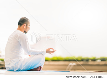 Young man meditating by swimming pool,yoga concept 26114860