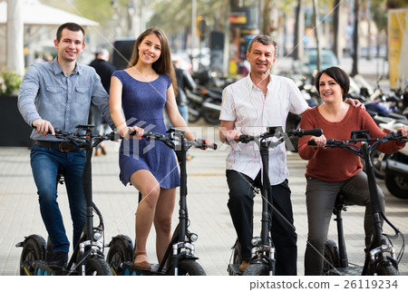 Adults traveling through city by bicycles. Adults traveling through city by bicycles. 26119234