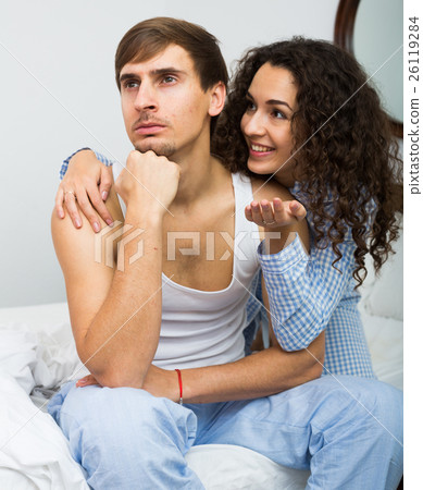 Smiling girl trying to comfort upset husband 26119284
