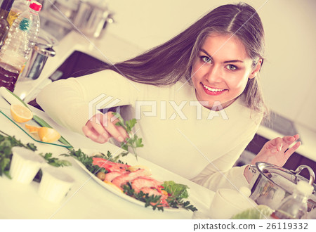 Girl decorating fried fish on plate Girl decorating fried fish on plate 26119332