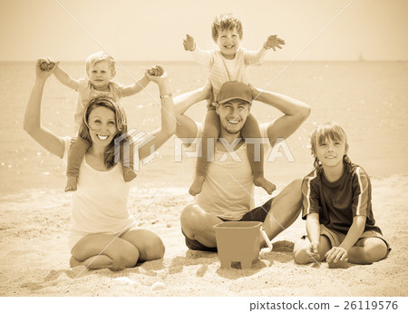 Happy family of five smiling at sea beach 26119576