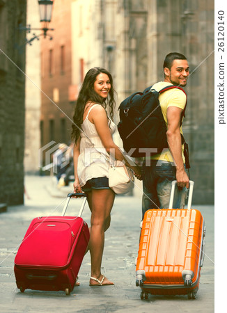 Travelers with baggage in the street 26120140
