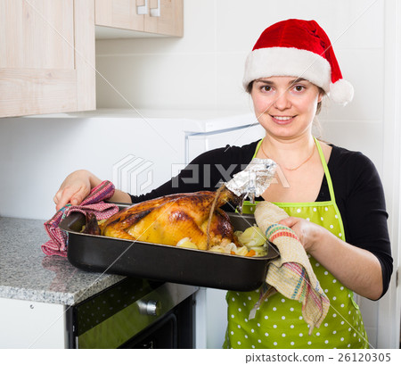 smiling brunette girl cooking capon 26120305