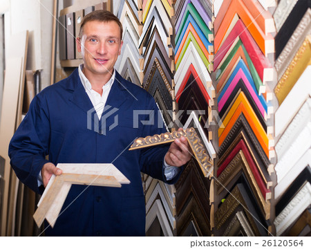 Smiling man seller in picture framing studio with wooden details Smiling man seller in picture framing studio with wooden details 26120564