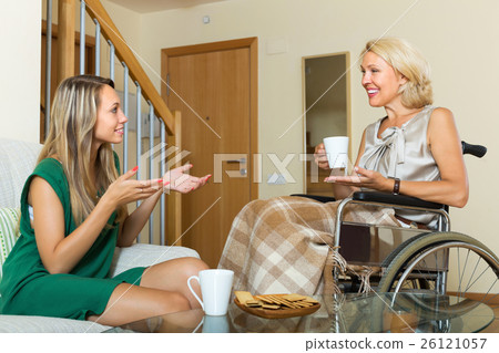 Female friend visiting disabled woman Female friend visiting disabled woman 26121057