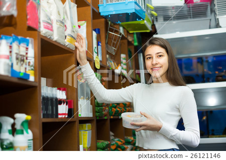 Girl watching dry food in pet store. 26121146