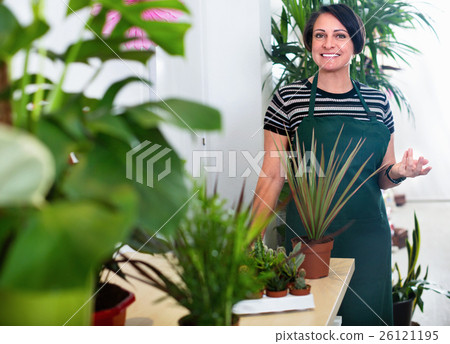 Glad woman florist smiling among the potted plants Glad woman florist smiling among the potted plants 26121195