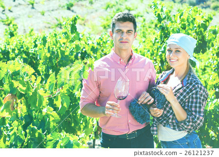 Two farmers posing with wine and grape Two farmers posing with wine and grape 26121237