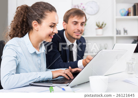portrait of business woman sitting with laptop on desk in office on working day 26121645