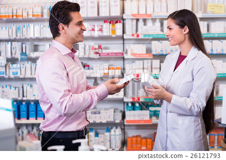 Pharmacist and customer in drugstore . 26121793