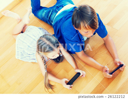 Positive siblings playing with phones 26122212