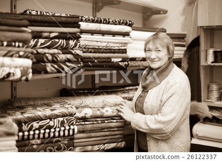 woman chooses tissue at fabric store 26122337