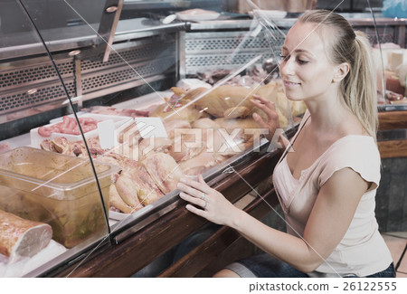 Woman customer buying fresh chicken parts in meat shop Woman customer buying fresh chicken parts in meat shop 26122555