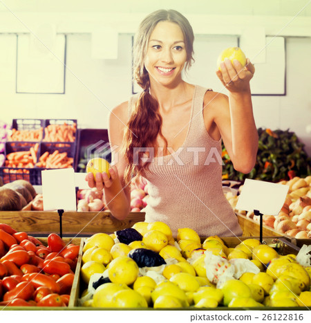 Young woman customer choosing lemons Young woman customer choosing lemons 26122816