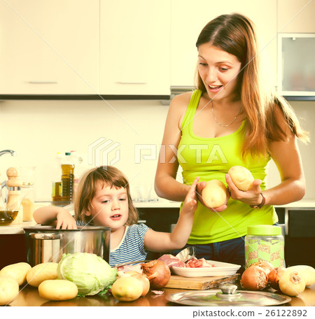 Happy woman with baby cooking with potatoes Happy woman with baby cooking with potatoes 26122892
