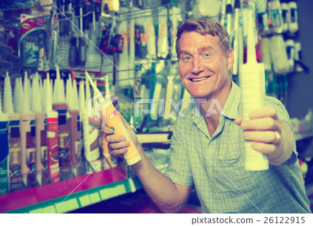mature man customer choosing sealant tube in hypermarket 26122915