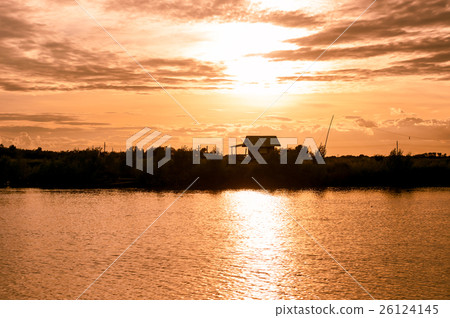 silhouette home riverside in yellow and gold sky silhouette home riverside in yellow and gold sky 26124145