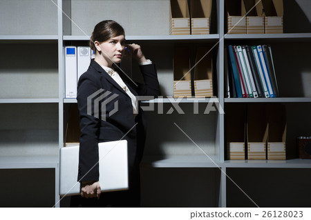 Business woman nestling in front of a bookshelf 26128023