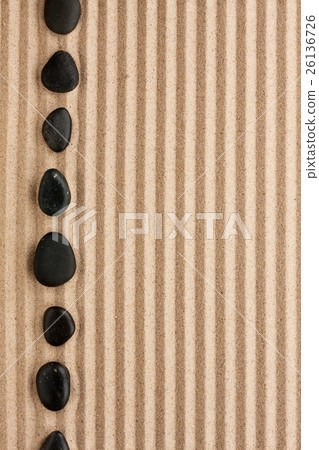 Black  stones lie on the sand 26136726