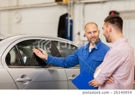 auto mechanic with clipboard and man at car shop 26140959