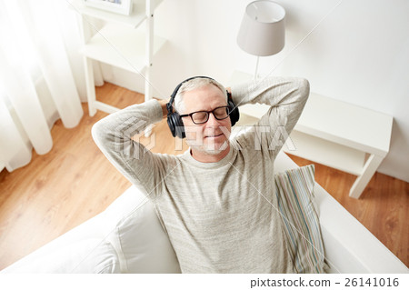 happy man in headphones listening to music at home 26141016