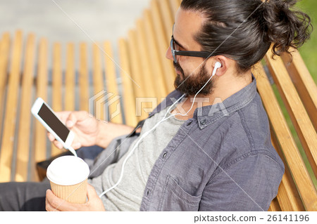 man with earphones and smartphone drinking coffee man with earphones and smartphone drinking coffee 26141196