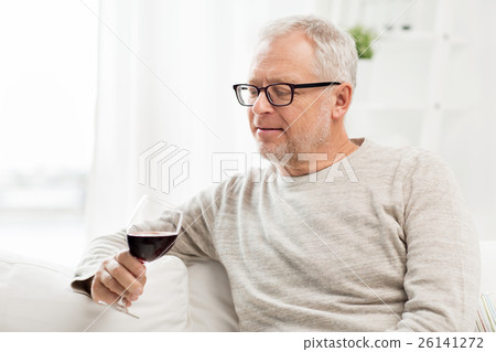 senior man drinking red wine from glass at home 26141272