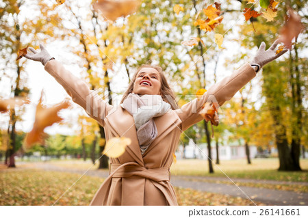 happy woman having fun with leaves in autumn park 26141661