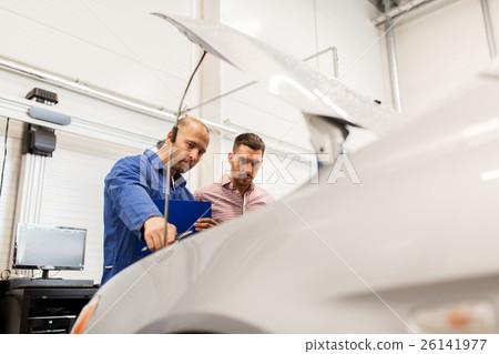 auto mechanic with clipboard and man at car shop 26141977